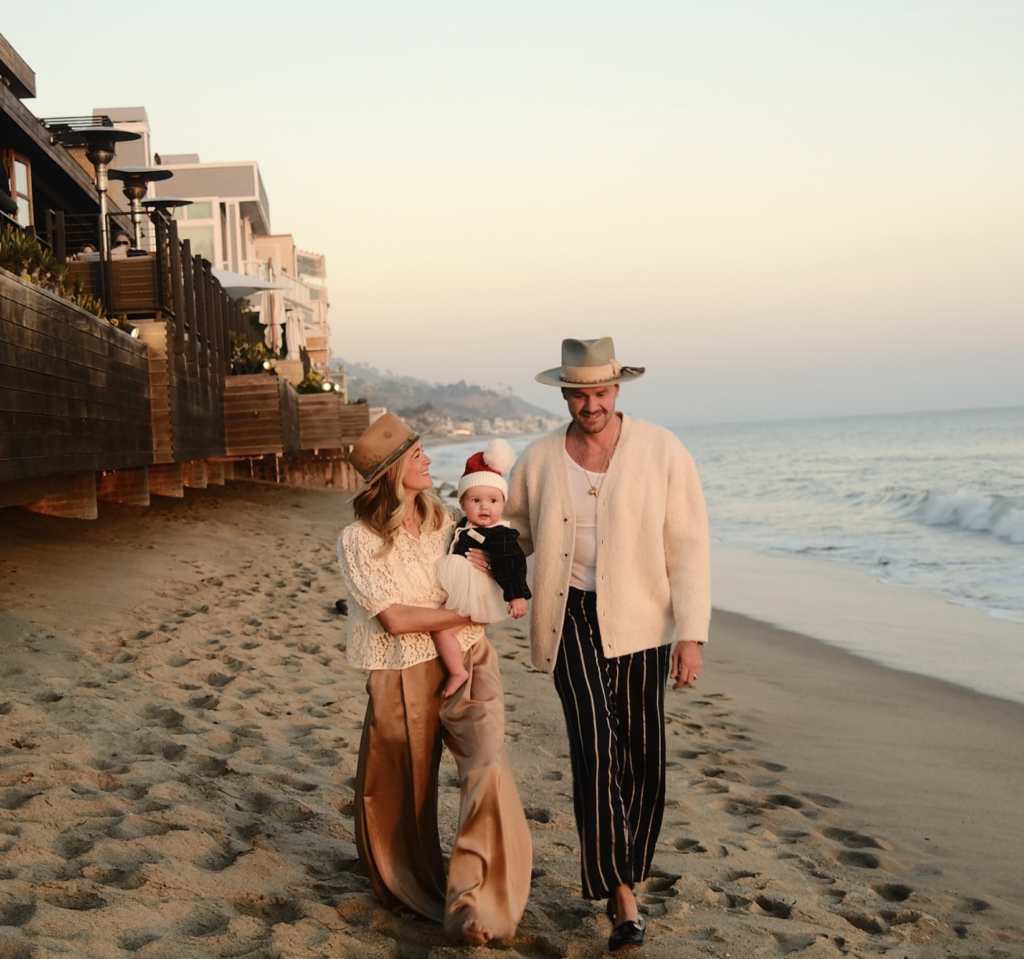 Teressa Foglia & Ty Hays stroll the beaches of Malibu with their baby before the fires destroyed the area. (Instagram photo)